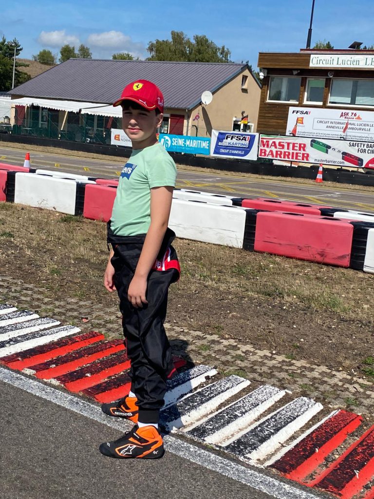 Le jeune pilote au bord du circuit, casque à la main.