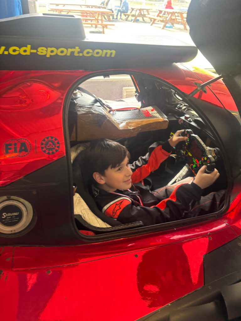 Le jeune passionné découvre le cockpit d’une voiture de course.