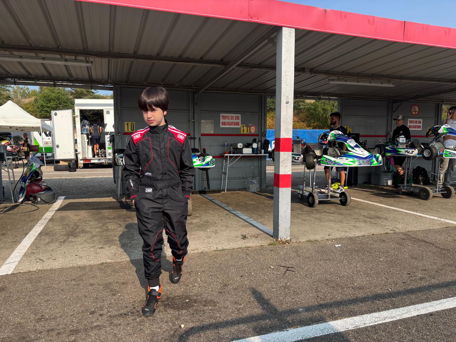 Le jeune pilote en combinaison dans le paddock du circuit.